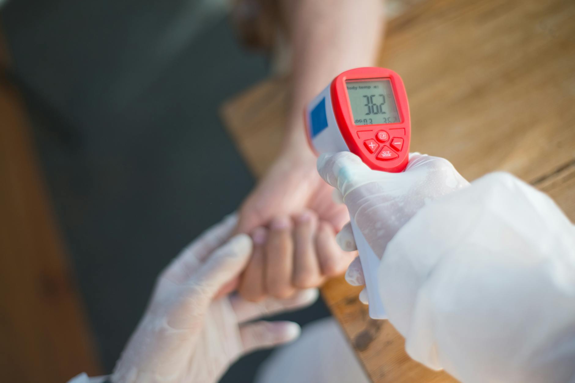 a person holding an infrared thermometer
